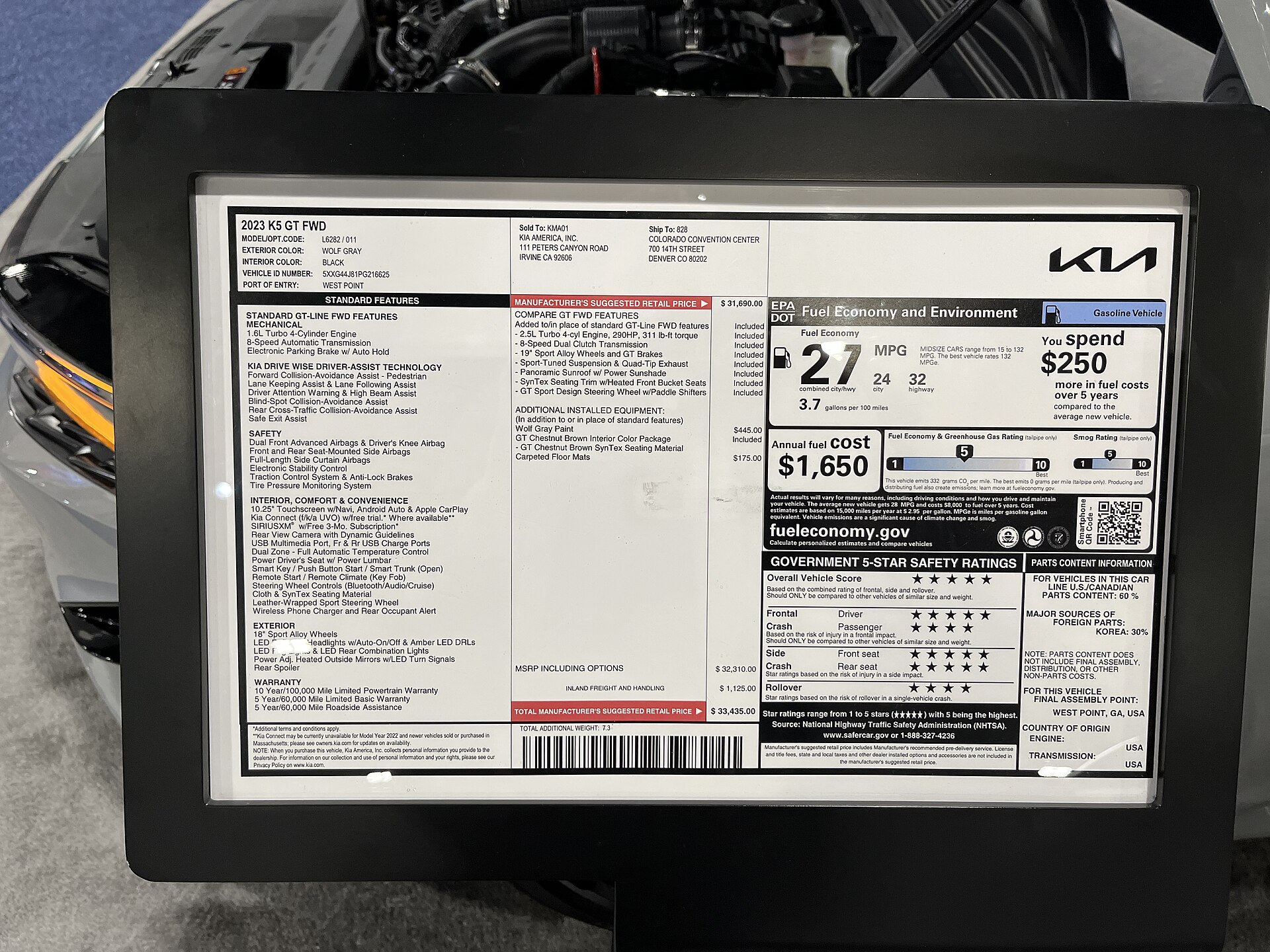 Close-up photograph of a dealership vehicle window sticker showing equipment and pricing information.
