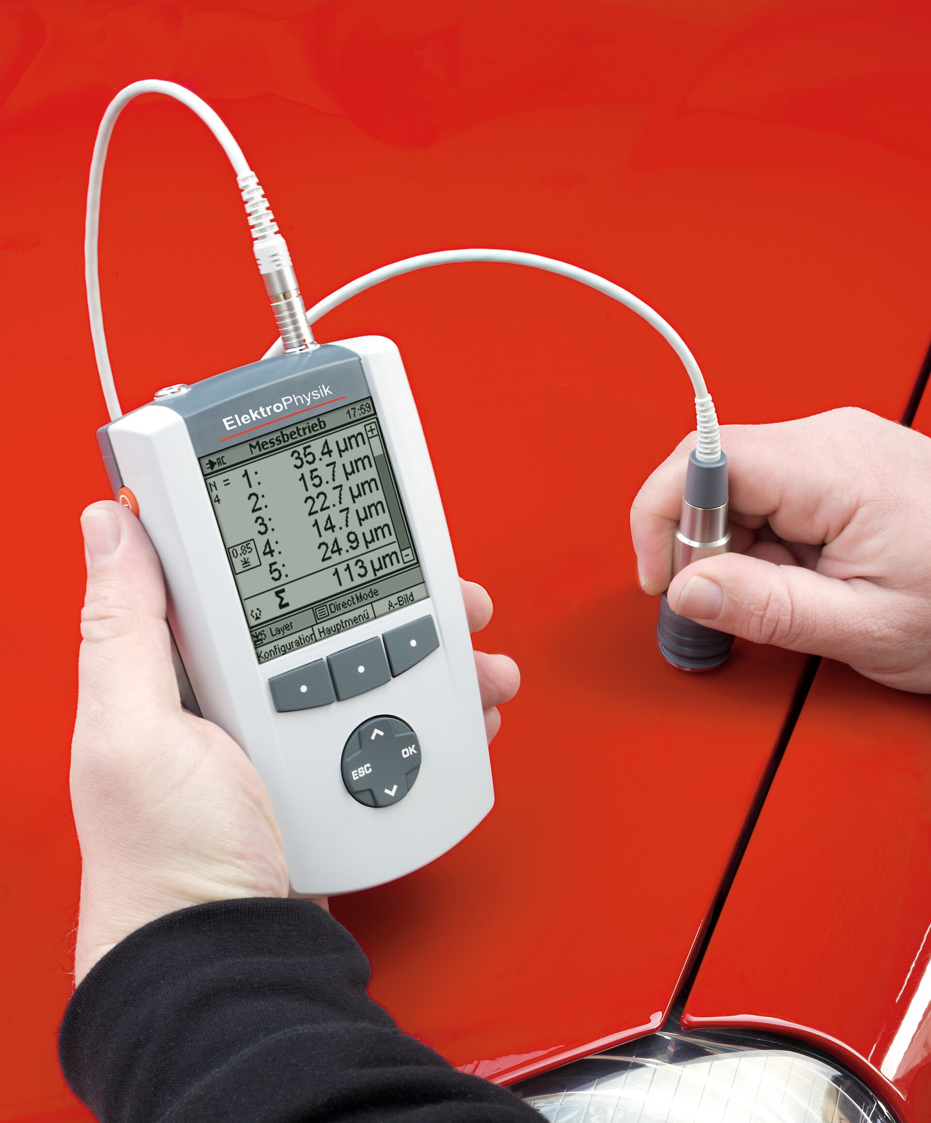 Ultrasonic coating-thickness gauge measuring a multilayer paint system on an automobile body panel.