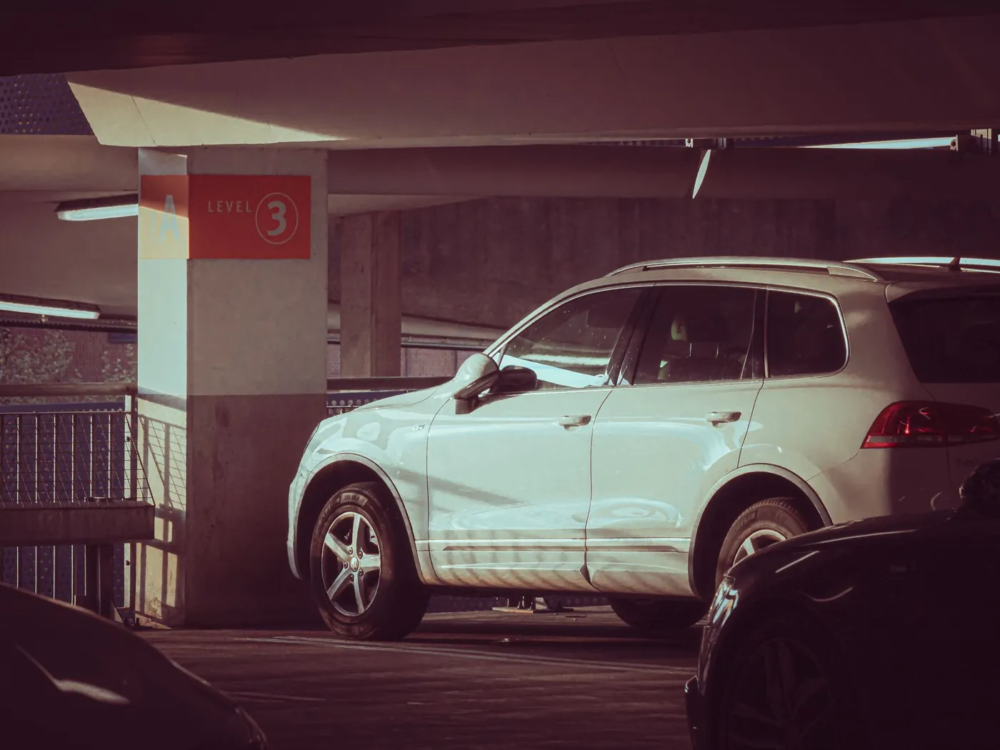 White compact SUV parked in a dim parking garage at night.